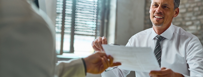 Happy businessman taking resume from a candidate during job inte